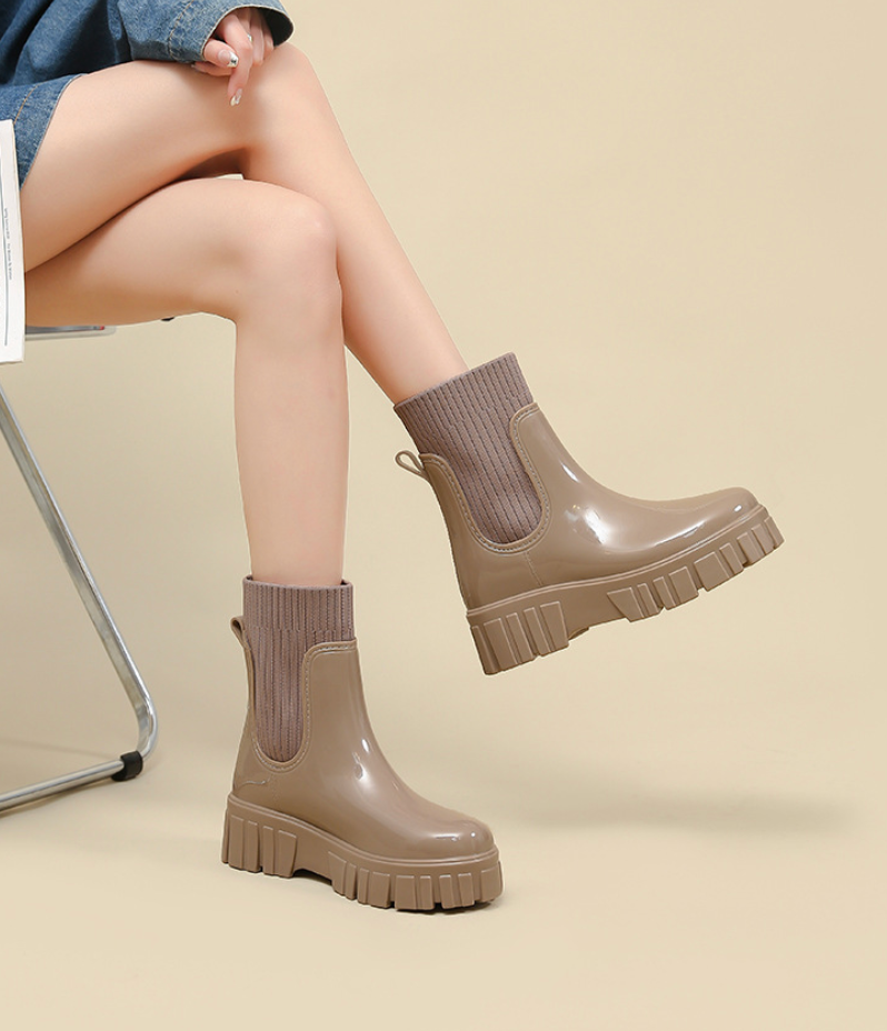 Mescini khaki glossy platform chelsea rain boots, worn while seated on a chair, US women's sizes