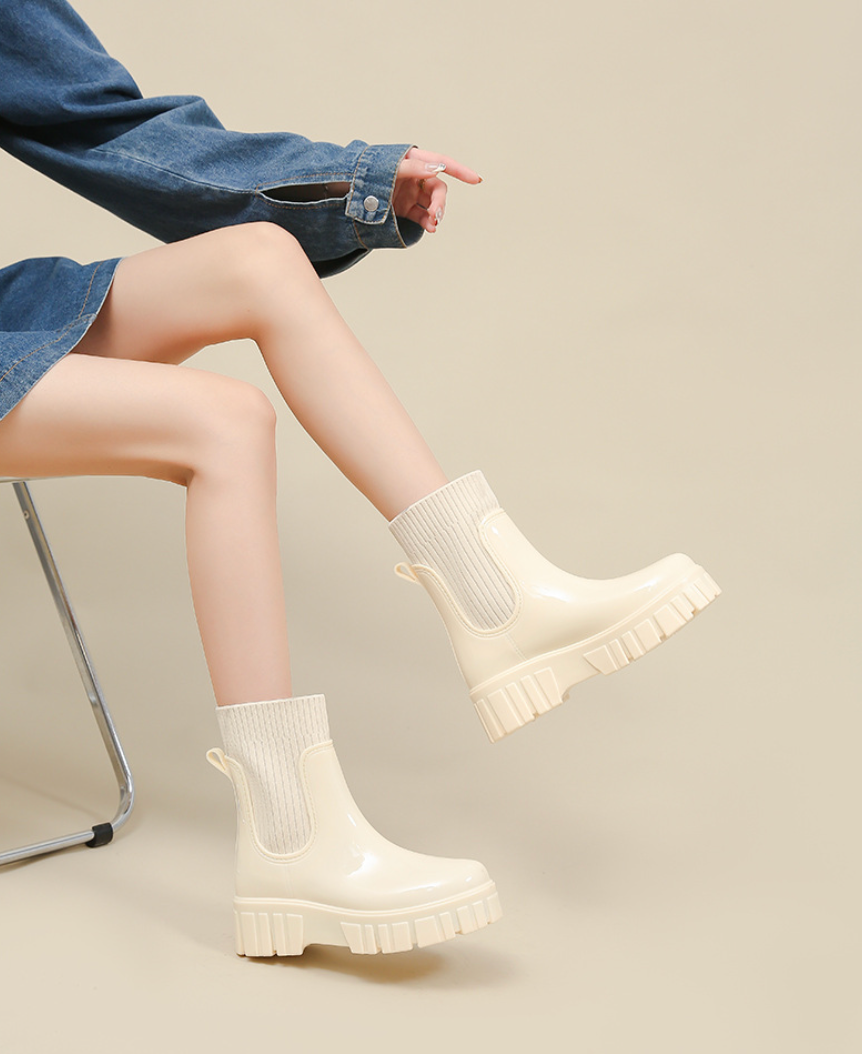 Mescini ivory glossy platform chelsea rain boots, worn while seated with denim, US women's sizes