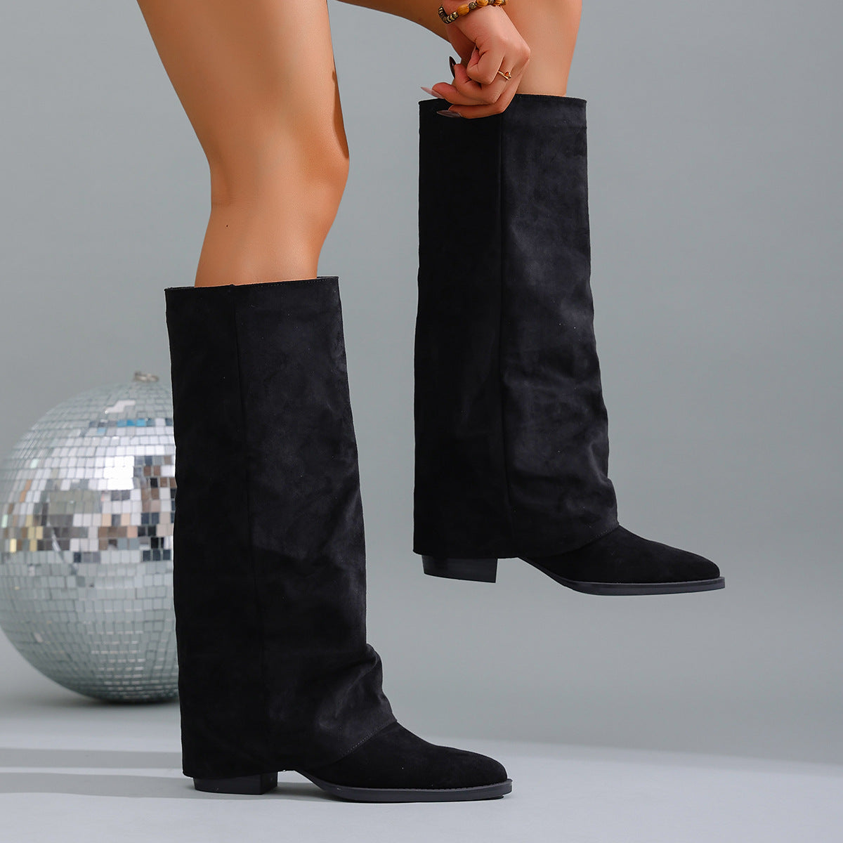 Mescini black fold over knee high boots worn beside a mirror ball, US women's sizes