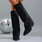 Mescini black fold over knee high boots worn with one leg lifted back, US women's sizes