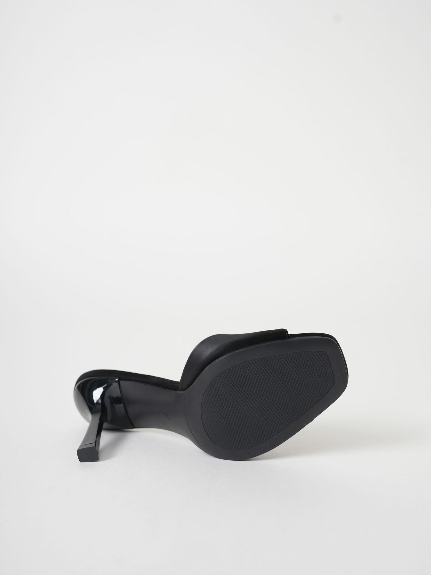 Mescini black wide band square toe mule on its side, the outsole facing out, US women's sizes