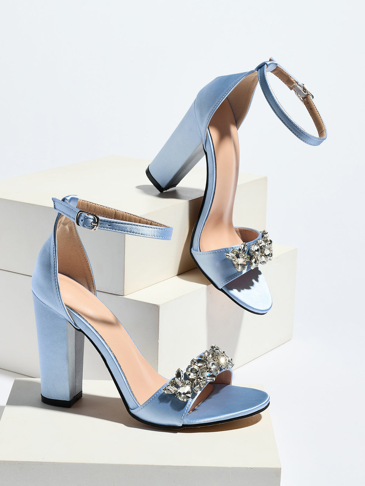 Mescini light blue crystal strap block heel sandals, pair posed on white display blocks, US women's sizes