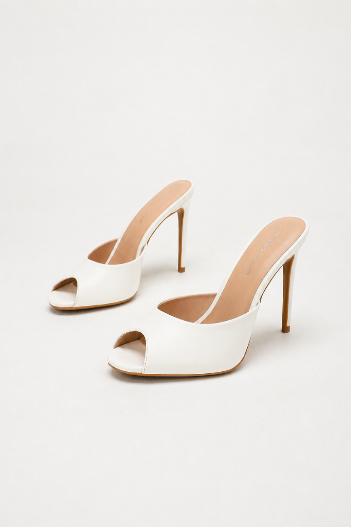 Mescini white sculpted peep toe stiletto mules, angled pair on an ivory background, US women's sizes