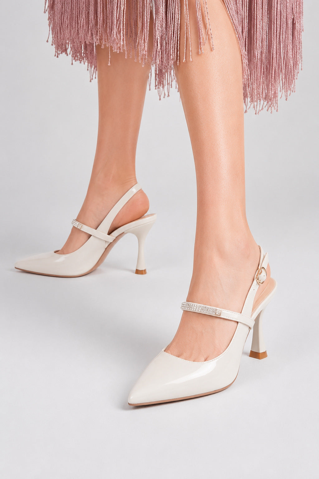 Mescini white crystal strap pointed slingback pumps, worn on the model mid stride, US women's sizes