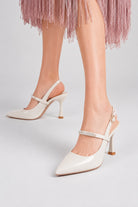 Mescini white crystal strap pointed slingback pumps, worn on the model mid stride, US women's sizes