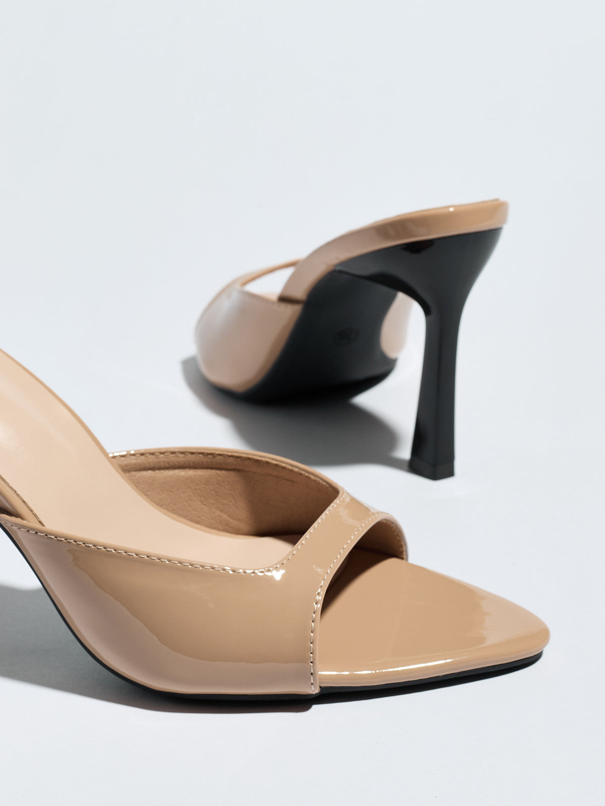 Mescini nude square open toe stiletto mules, close up of the vamp with one shoe tipped, US women's sizes