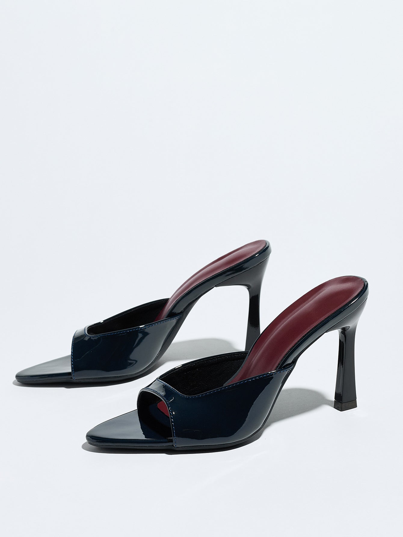 Mescini navy square open toe stiletto mules, pair set at an angle on grey, US women's sizes