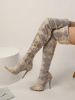 Mescini cream snake print thigh high stiletto boots, worn by the model seated on a low block, US women's sizes