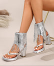 Mescini silver fringe thong chunky heel sandals, worn by a seated model against a pale wall, US women's sizes