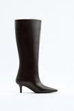 Mescini dark brown pointed toe knee high boots, full side view on a studio backdrop, US sizes