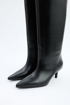 Mescini black pointed toe knee high boots, worn with the shaft standing clear, US sizes