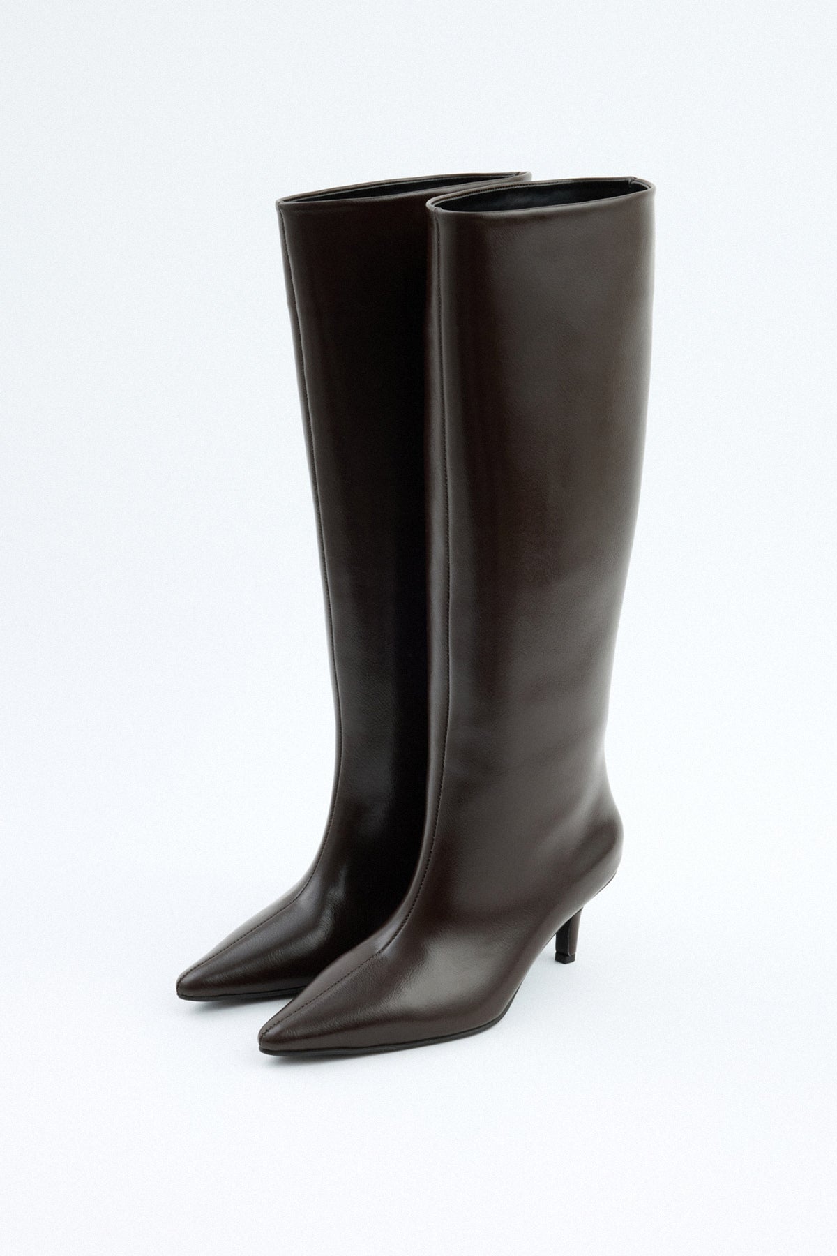 Mescini dark brown pointed toe knee high boots, angled pair view on a pale floor, US sizes