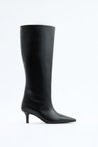 Mescini black pointed toe knee high boots, full side view on a studio backdrop, US sizes