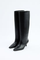 Mescini black pointed toe knee high boots, worn on the leg under a long skirt, US sizes