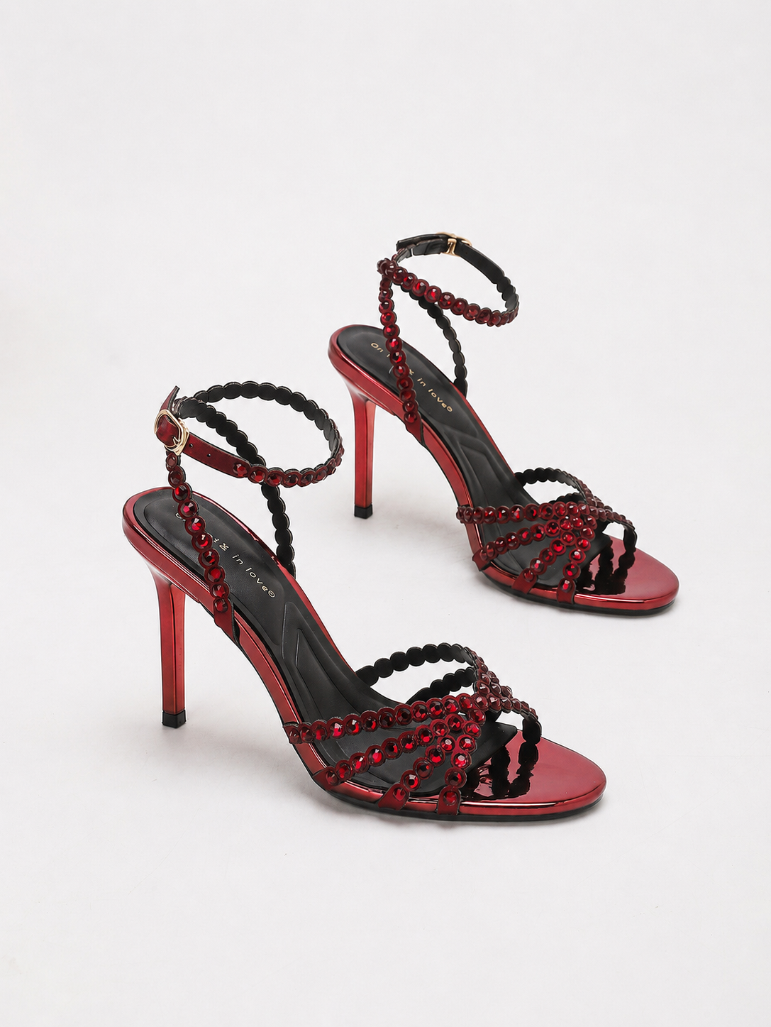 Mescini red rhinestone strappy stiletto sandals, the pair angled on a light background, US women's sizes