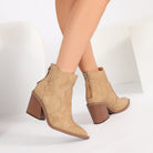 Mescini beige pointed toe western ankle boots, worn feet together on a white floor, US women's sizes