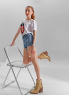 Mescini beige pointed toe western ankle boots, full length model standing by a chair, US women's sizes