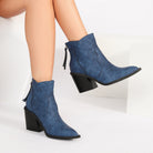 Mescini blue pointed toe western ankle boots, worn with one foot lifted forward, US women's sizes