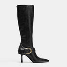 Mescini black buckled pointed toe knee high boots, single shoe at an angle on grey, US women's sizes