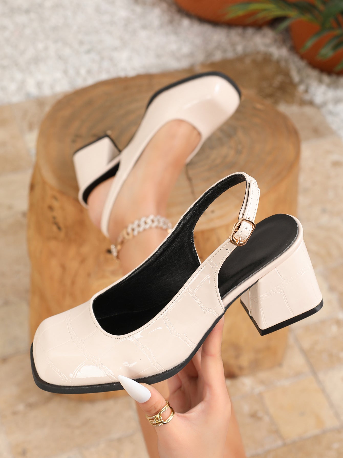 Mescini apricot croc patent square toe slingback heel, held up in one hand, US women's sizes