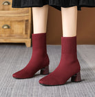 Mescini burgundy knit square toe sock ankle boots, worn standing on a grey rug, US women's sizes