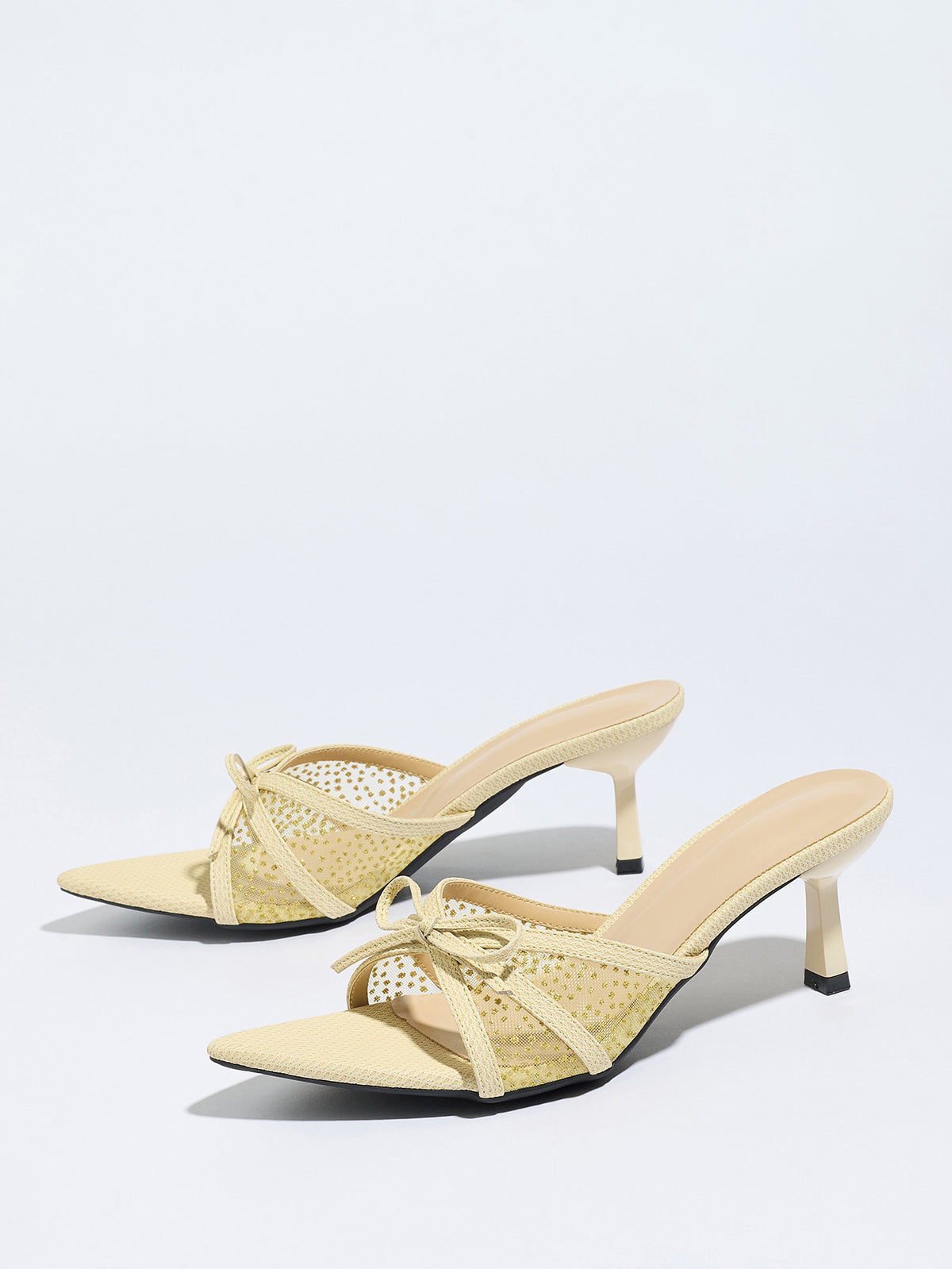 Mescini apricot bow mesh pointed toe mule heels, the pair angled on a white ground, US women's sizes