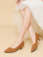 Mescini brown knit pointed toe kitten heel pumps, worn under a white skirt, US women's sizes