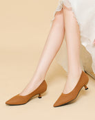 Mescini brown knit pointed toe kitten heel pumps, worn standing under a white hem, US women's sizes