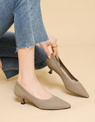 Mescini khaki knit pointed toe kitten heel pumps, worn with jeans, hand at one shoe, US women's sizes
