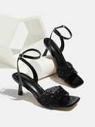 Mescini black rhinestone square toe heeled sandals, pair set on a white display block, US women's sizes