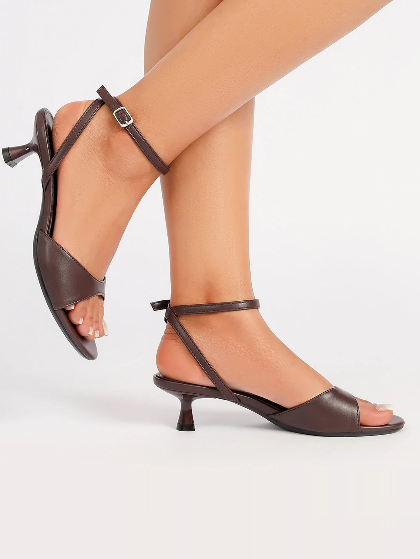 Mescini brown ankle strap kitten heel sandals worn while stepping forward, US women's sizes
