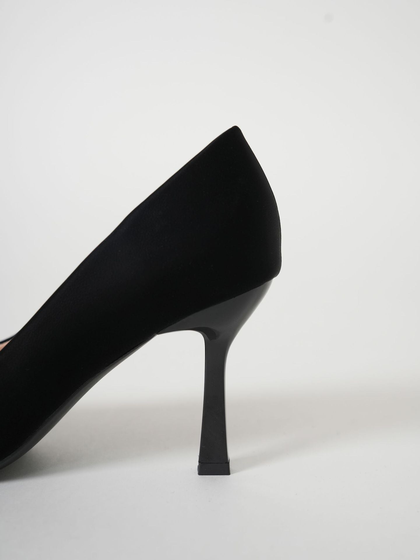 Mescini black pointed toe stiletto pumps, side profile of one shoe on grey, US women's sizes
