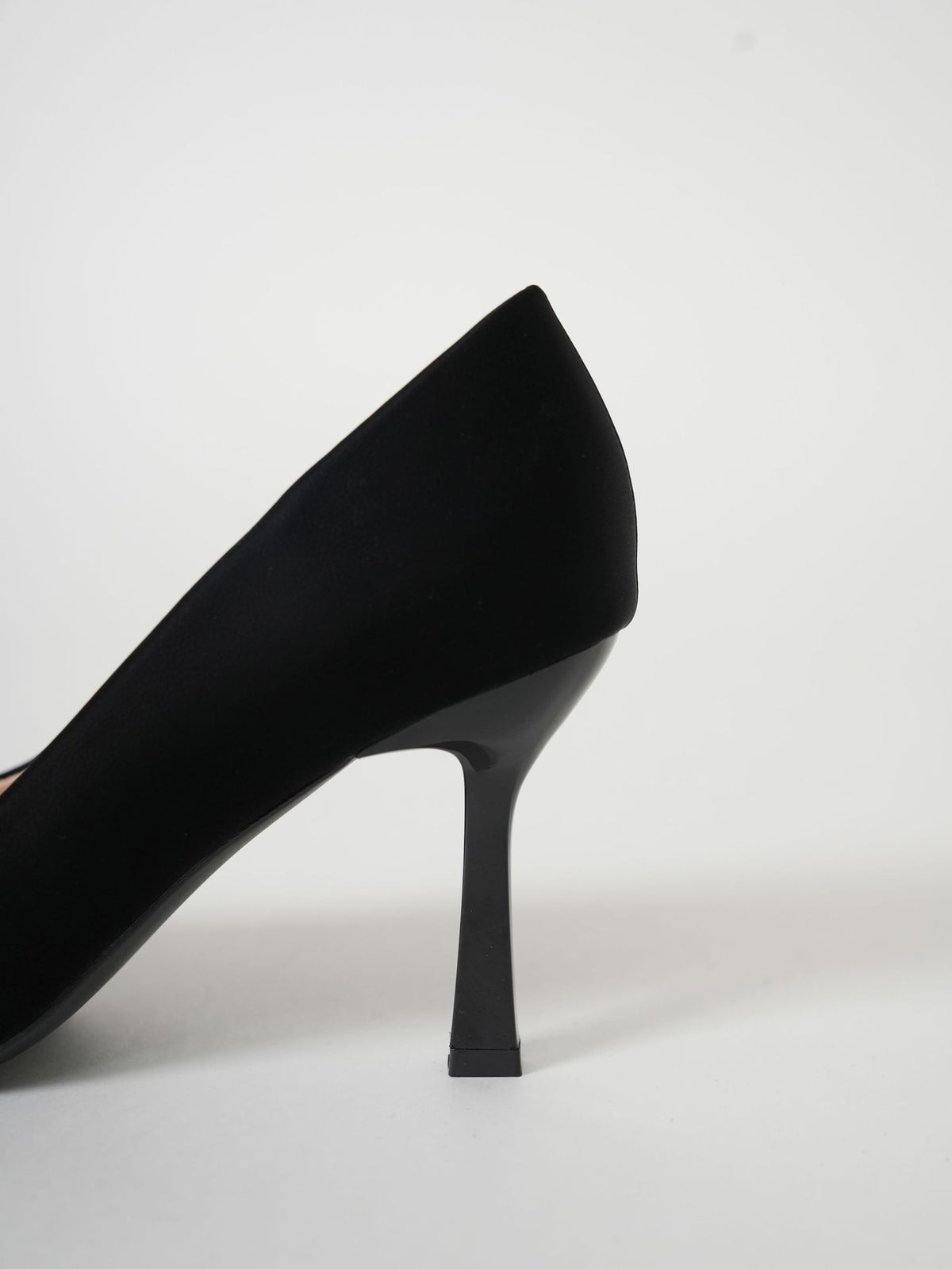 Mescini black pointed toe stiletto pumps, side profile of one shoe on grey, US women's sizes