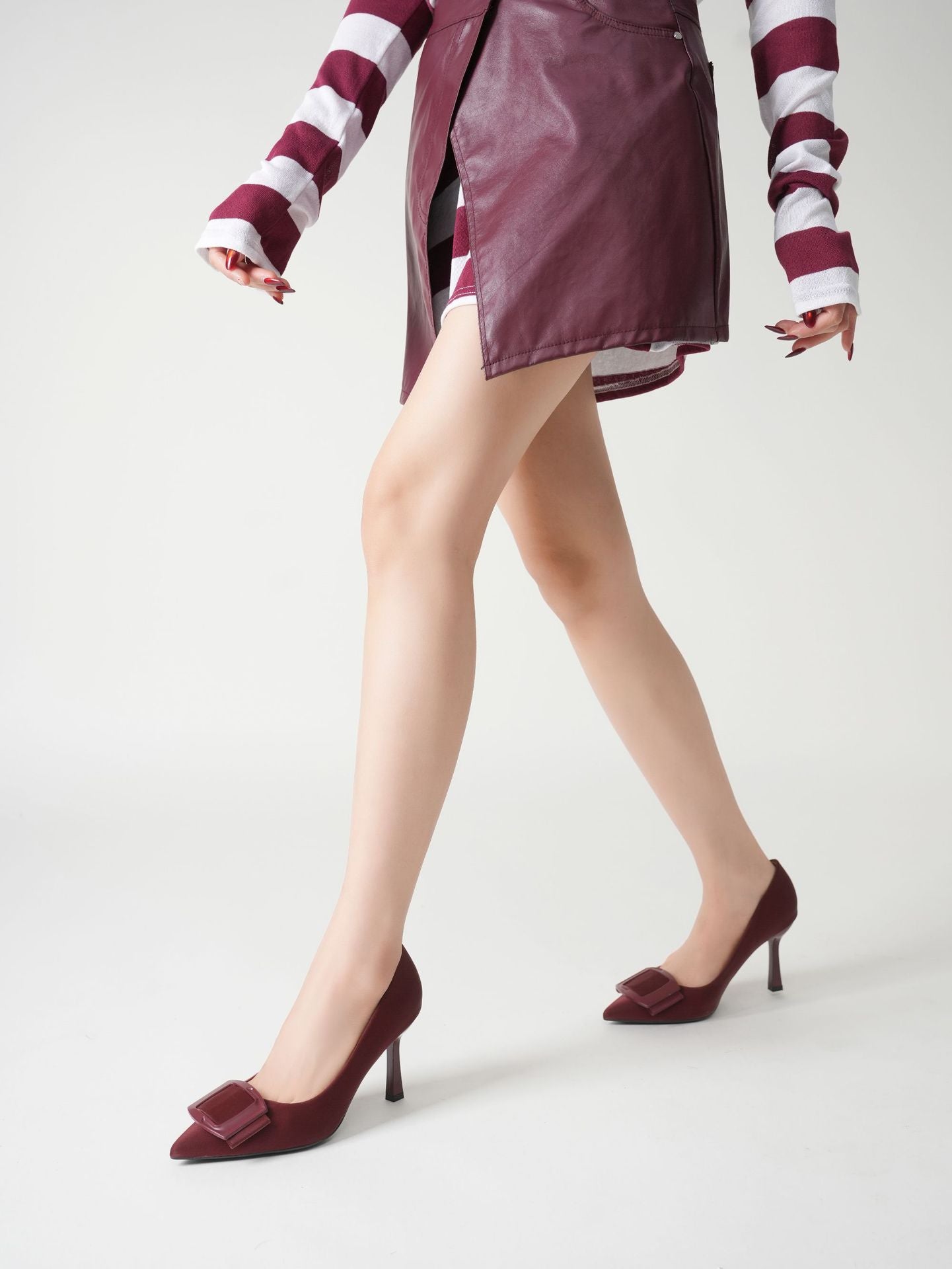Mescini burgundy pointed toe stiletto pumps, worn with a leather skirt and striped sleeves, US women's sizes