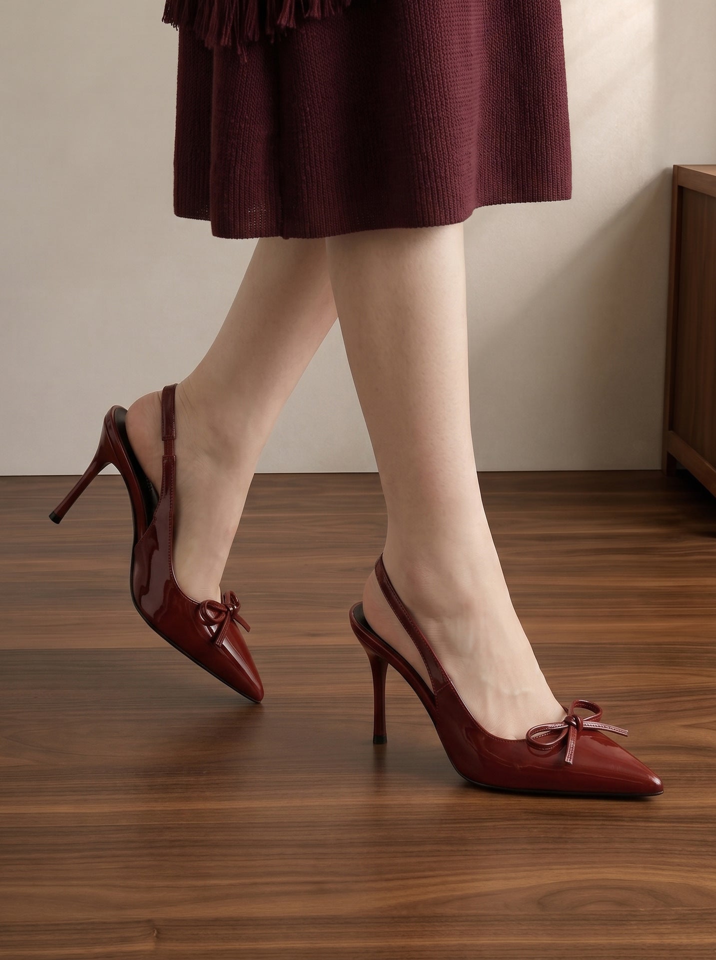 Mescini wine red patent bow slingback heels worn walking on a wooden floor, US women's sizes