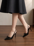 Mescini black patent bow slingback heels worn walking away from the camera, US women's sizes