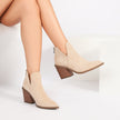 Mescini khaki V-cut pointed toe block heel ankle boots, worn by a seated model, US women's sizes