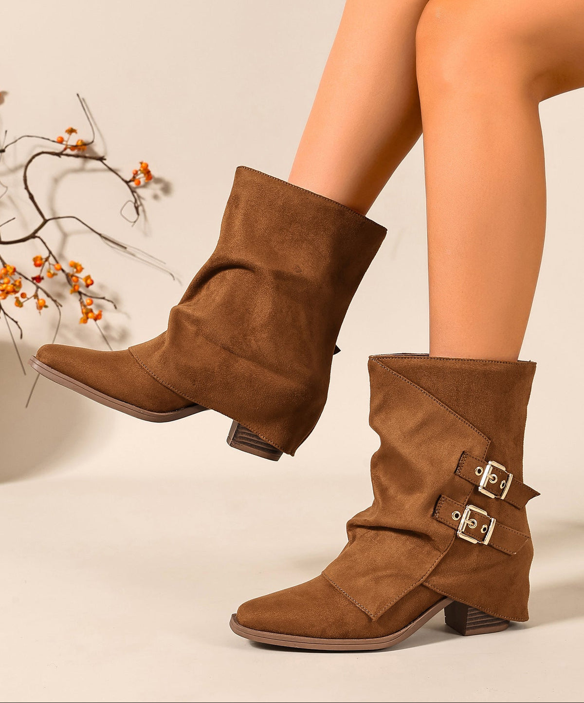 Mescini brown ruched buckle mid calf slouch boots worn with one toe forward, US women's sizes