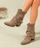 Mescini khaki ruched buckle mid calf slouch boots worn while walking, side view, US women's sizes