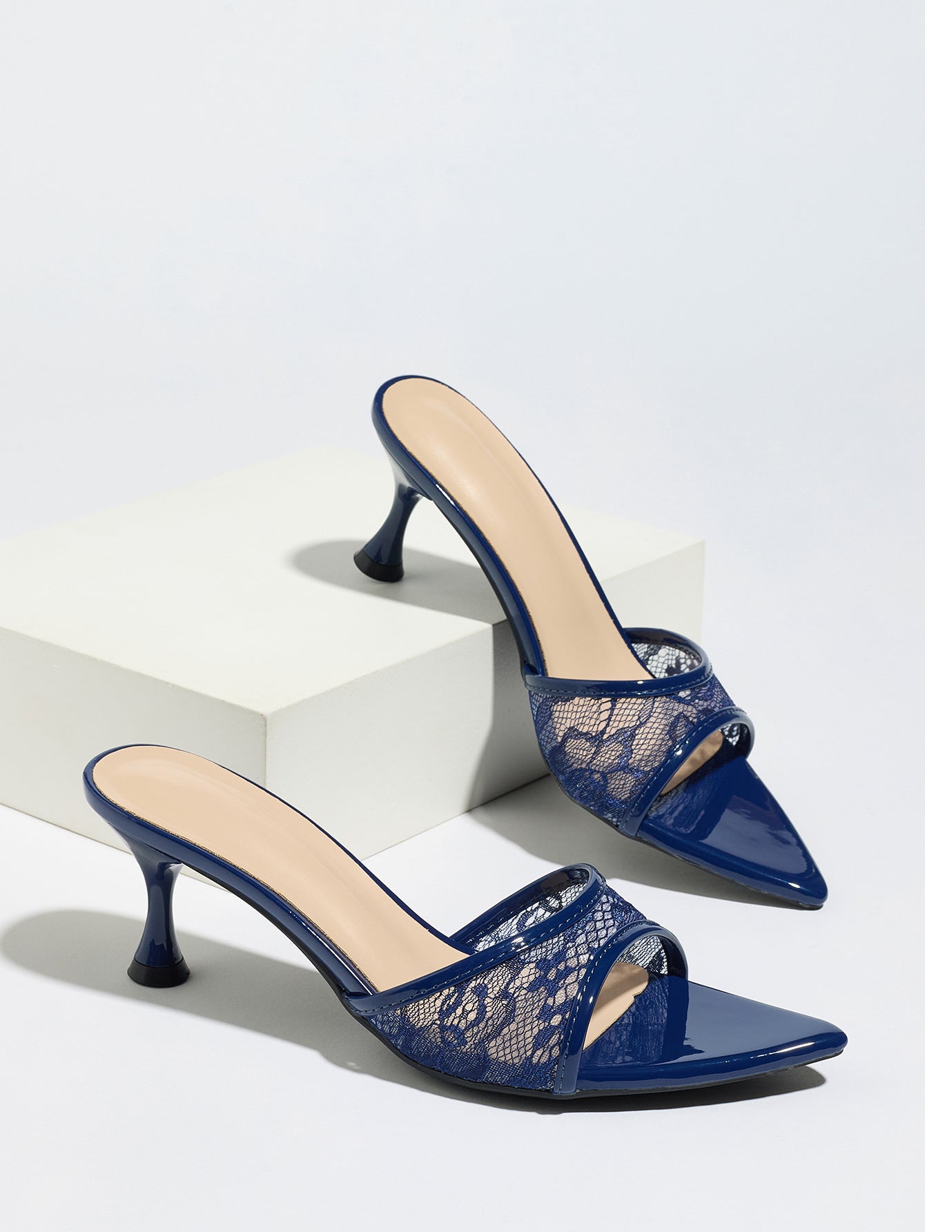 Mescini navy sheer lace pointed toe mule heels, pair staged on a white display block, US women's sizes
