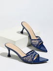 Mescini navy sheer lace pointed toe mule heels, pair staged on a white display block, US women's sizes