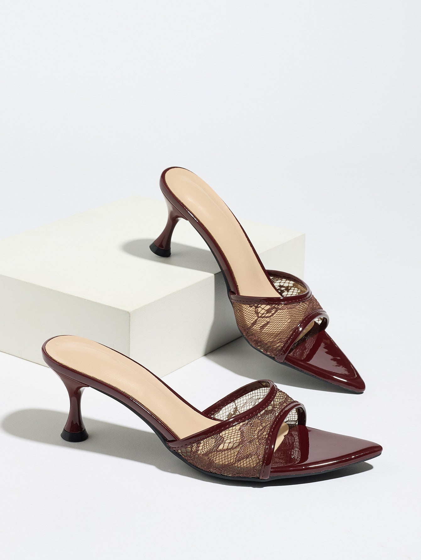 Mescini burgundy sheer lace pointed toe mule heels, pair resting on a white block, US women's sizes