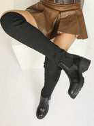 Mescini black ribbed knit over the knee platform boots, worn by a model reclining in a skirt, US women's sizes