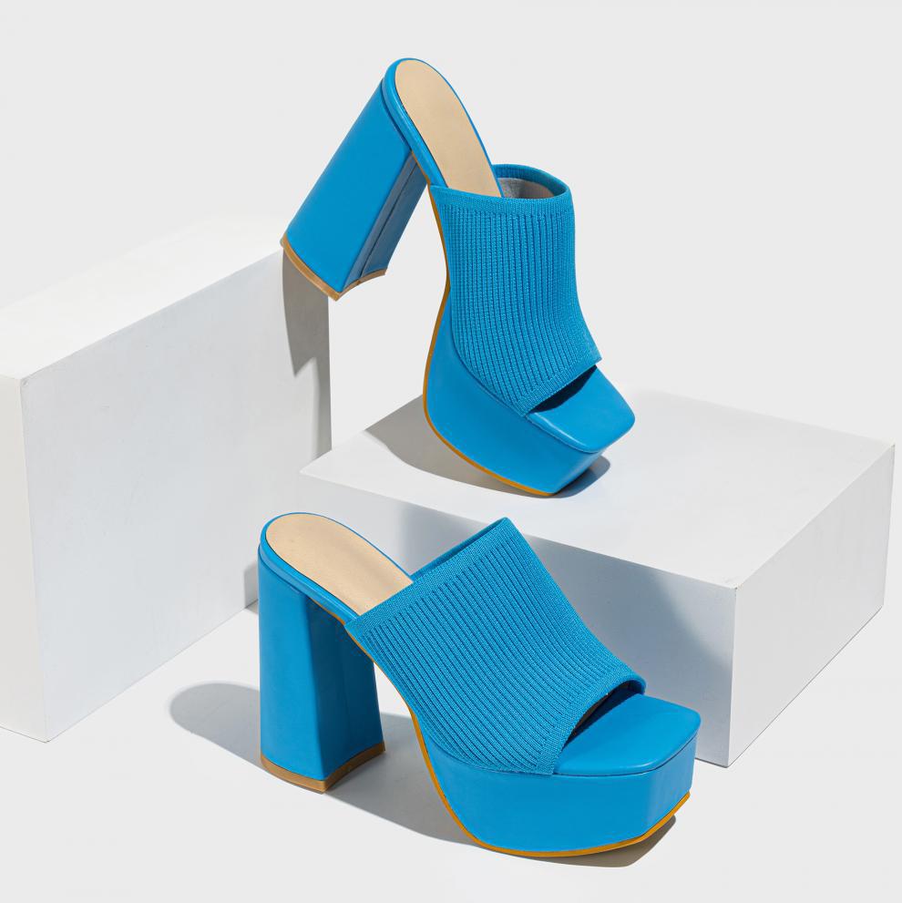 Mescini blue knit band platform mule heels, pair staged on white display blocks, US women's sizes