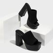 Mescini black knit platform mules staged on white blocks in a pair, US women's sizes