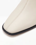 Close crop of the square toe and thin sole edge on Mescini cream stretch ankle boots