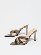 Mescini bronze cross strap stiletto mule sandals, pair angled on plain white, US women's sizes