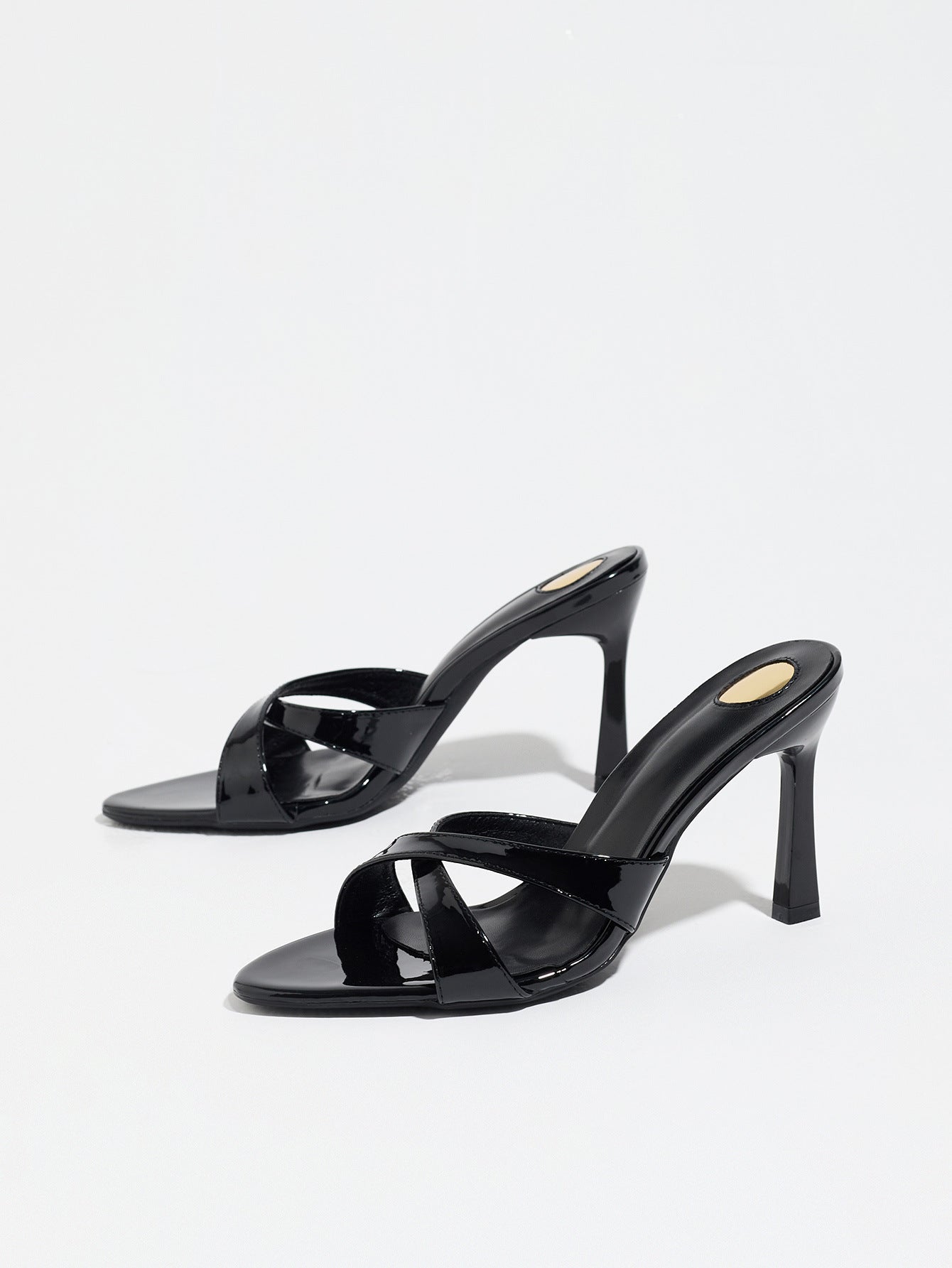 Mescini black cross strap stiletto mule sandals, pair angled on a white backdrop, US women's sizes