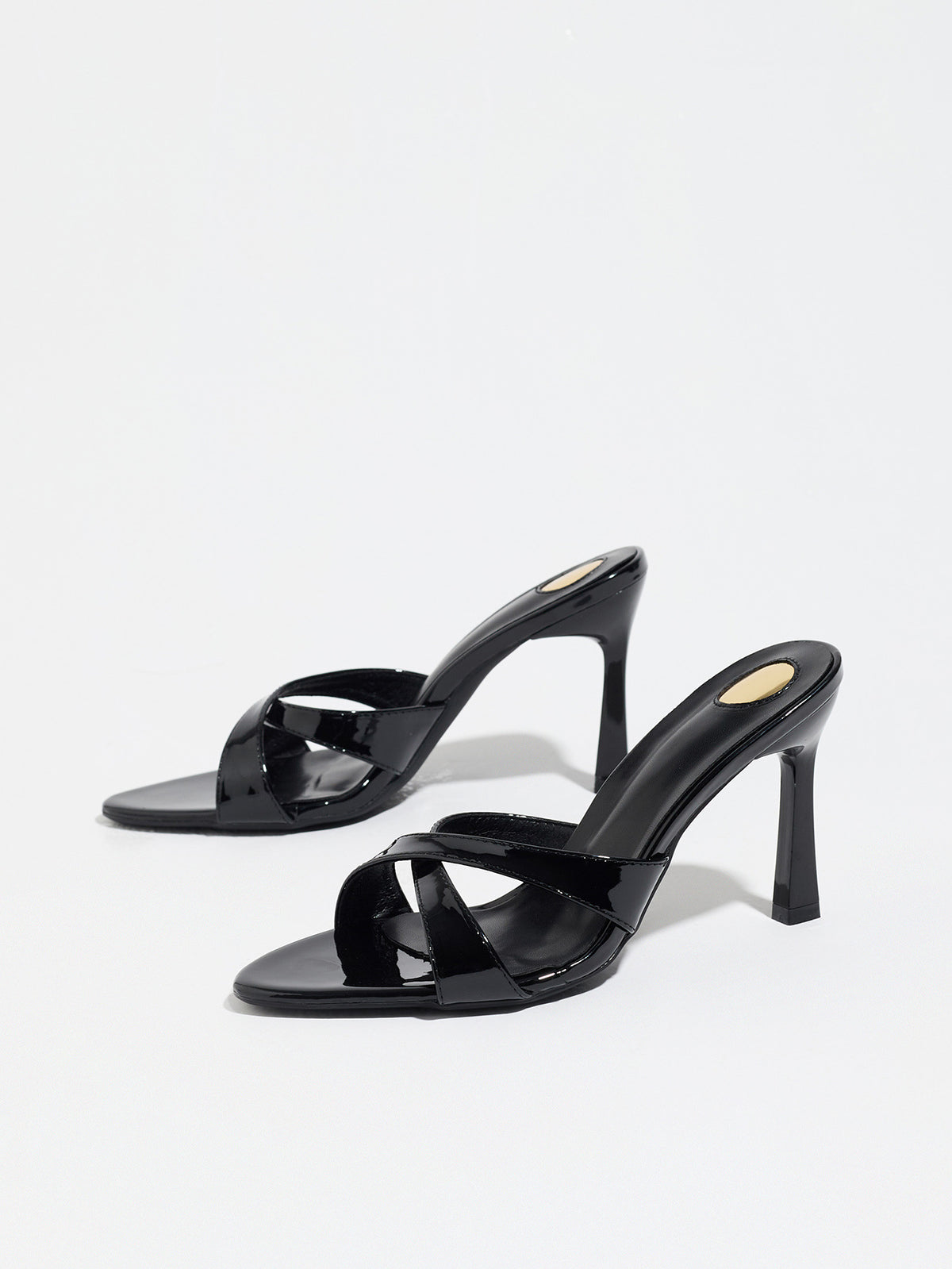 Mescini black cross strap stiletto mule sandals, pair angled on a white backdrop, US women's sizes