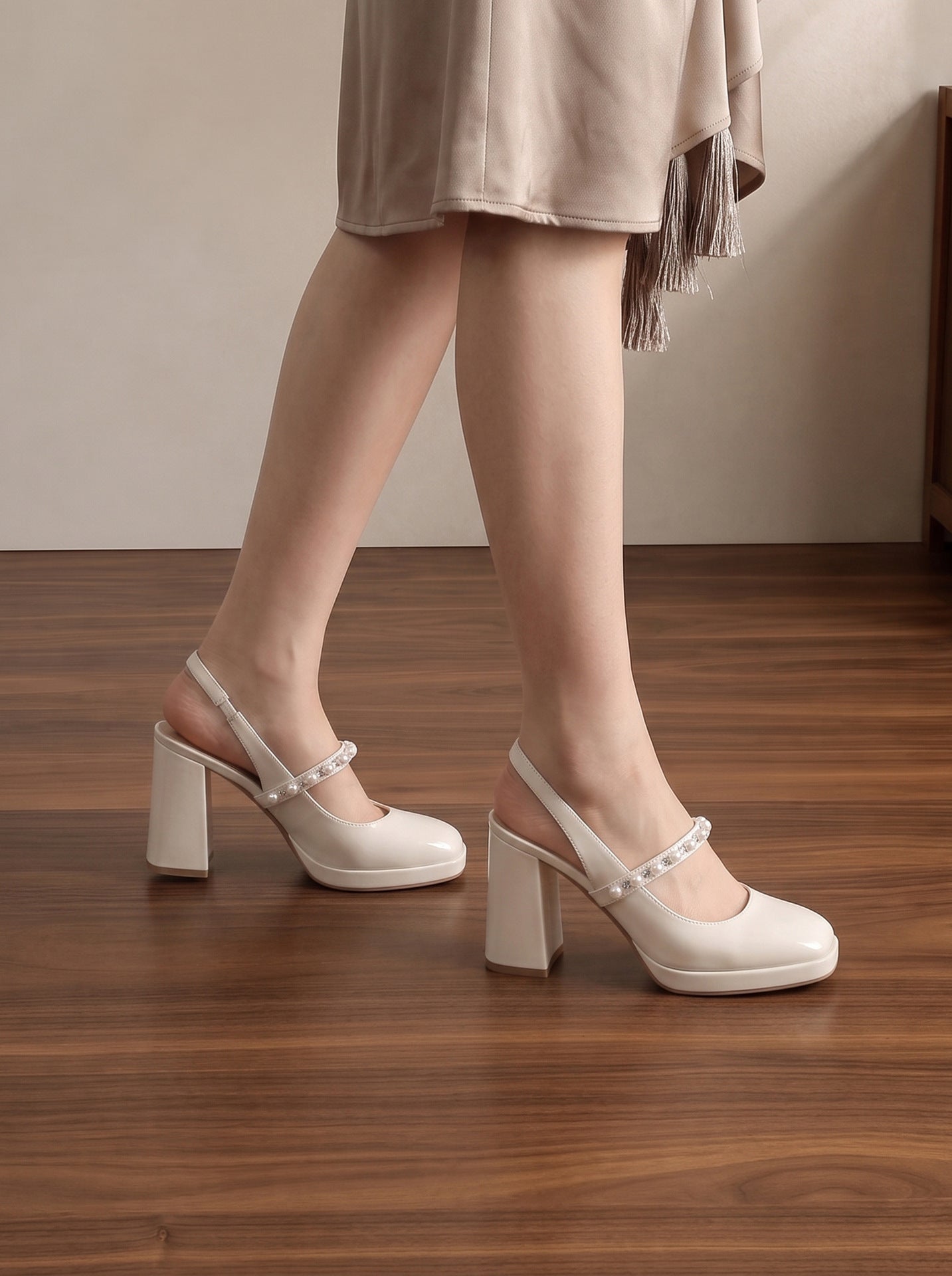 Mescini white pearl strap platform mary jane heels, worn on a model standing on wood, US women's sizes